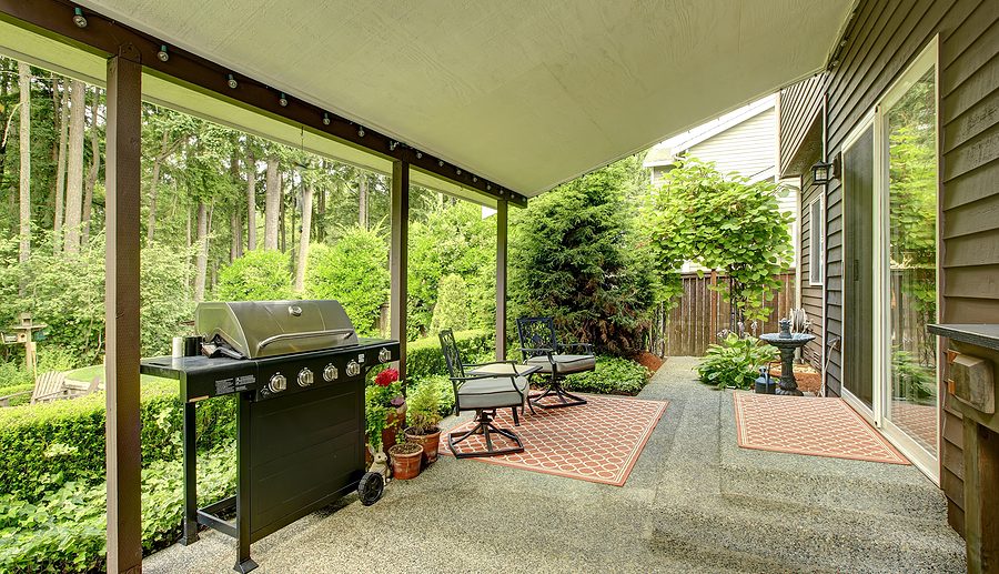 concrete walkout deck, with grill and surrounded plants